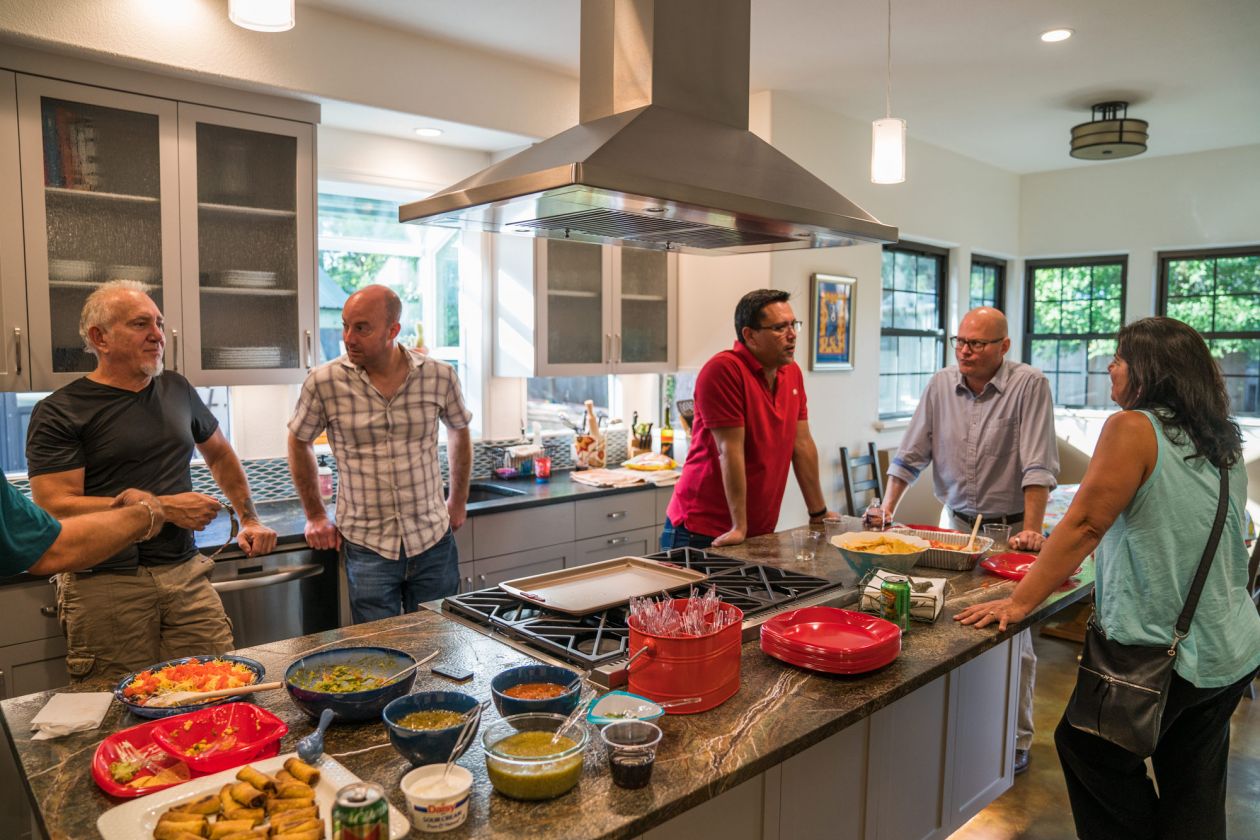 People Conversing Around Home Kitchen Island